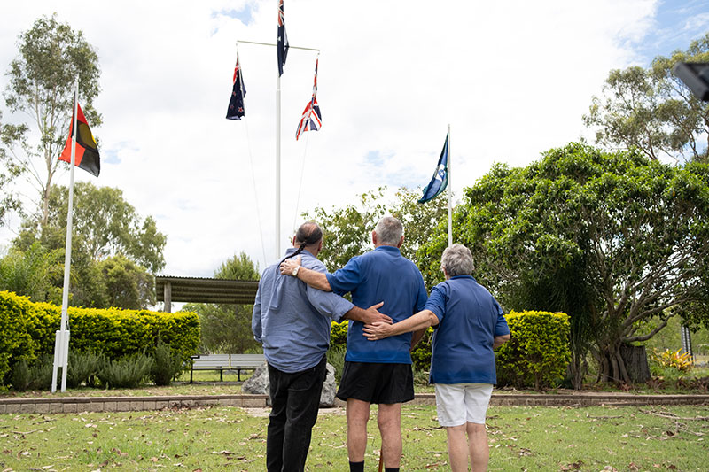 Mount Larcom RSL Sub Branch President Chris Feros in front of flagpole