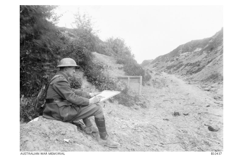 Lieutenant Will Dyson, sketching near Ville-sur Ancre, in France in 1918. Dyson was wounded twice while sketching but returned to the front to continue his work. Photographer unknown, AWM EO2437.
