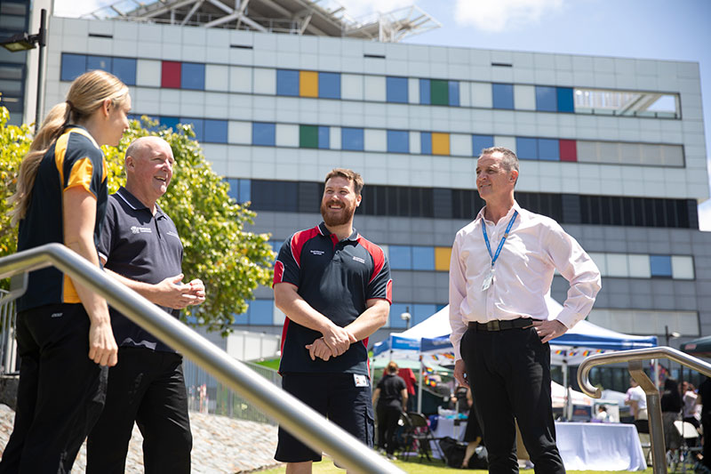 Ken Orr standing outside, chatting with Gold Coast Health staff