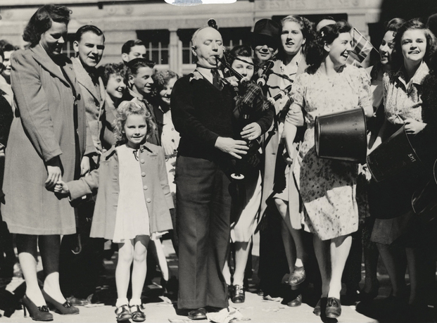 SGT Jock Hannon, formerly RAAF, plays bagpipes to celebrate Victory in the Pacific