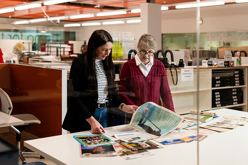 2 women reading QLD RSL News