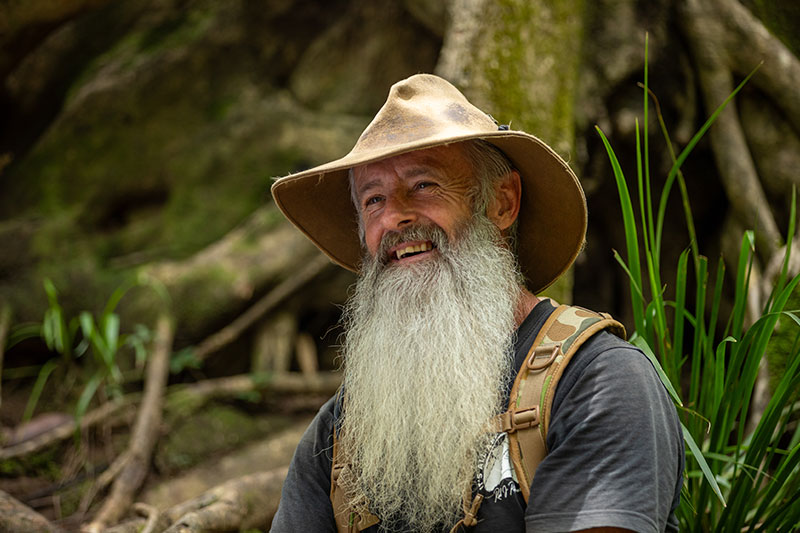 Rick Peterson sitting in front of a tree. 