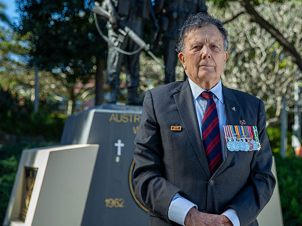 Vietnam Veteran Greg Gilbert wears medals and stands outside 