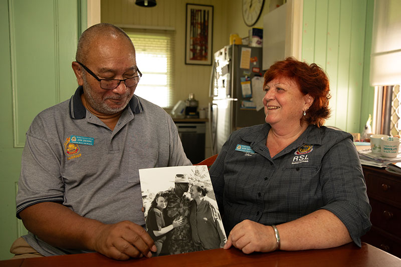 John and Naomi Enchong holding a photo from when John was serving. 