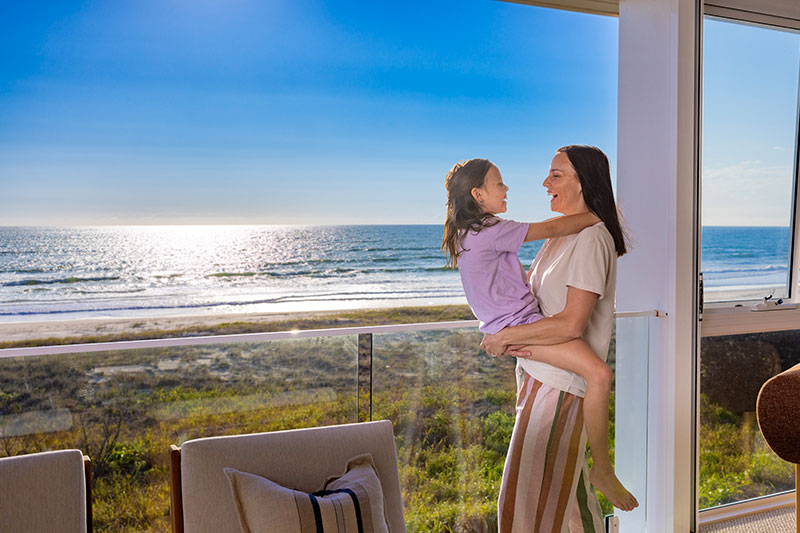 Mother and daughter embracing, smiling at each other. 