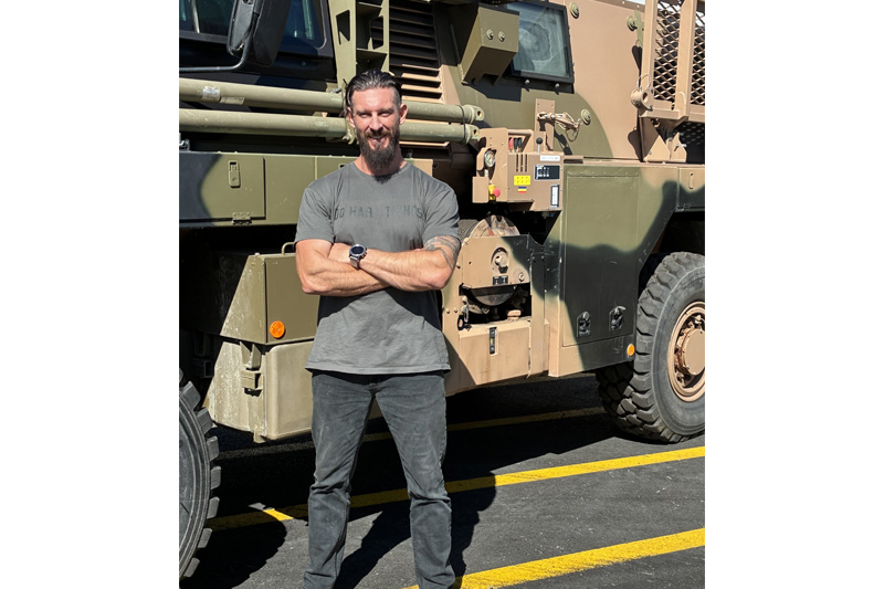 Ashley Semmens in front of the model of vehicle which saved his life in Afghanistan - the Aussie Bushmaster made by Australian company Thales